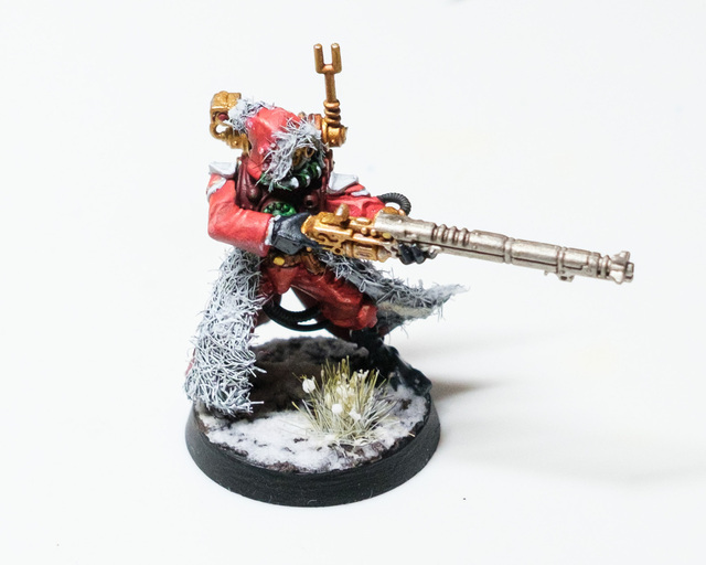 Photo of a Skitarii Ranger miniature painted like Father Christmas with red cloak, white ‘fur’ linings and on a snowy base