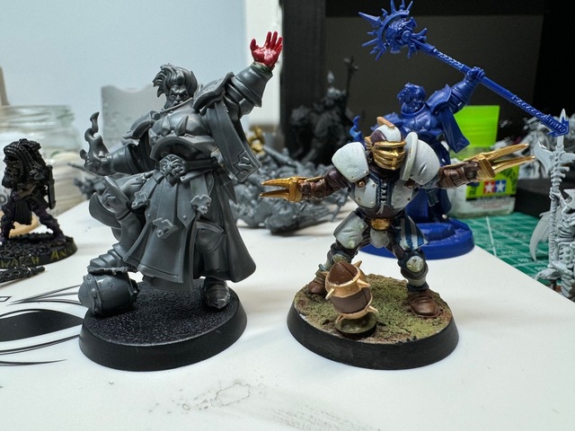 Photo of an unpainted converted Stormcast miniature, next to a painted Human Blood Bowl player miniature. The Stormcast miniature is taller by a head or so