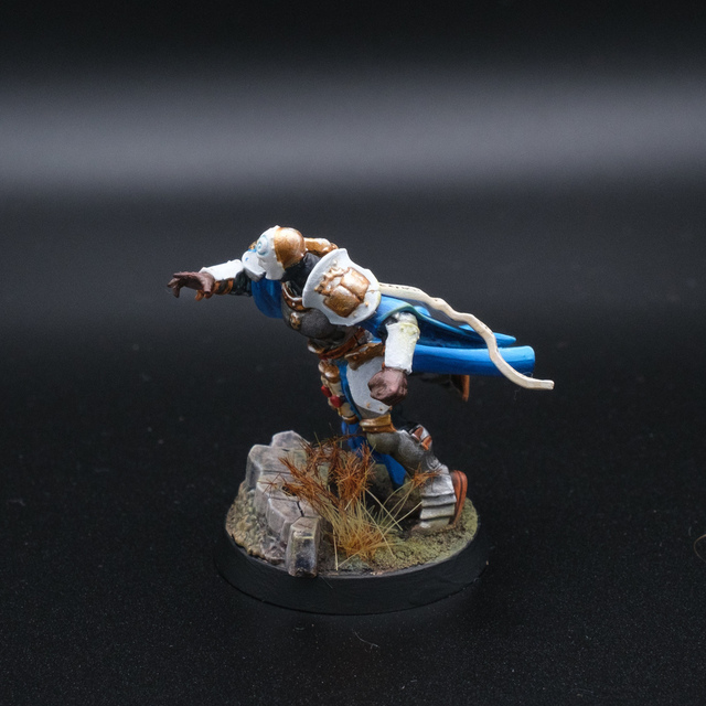 Photo of a painted Knight Incantor converted as a Blood Bowl player from the left side. The character looks to be diving forward, over some ruined cobbles.