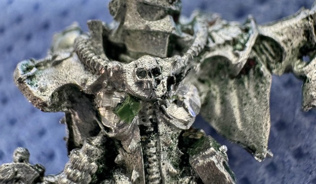 Cropped photograph showing a metal Sisters of Battle miniature with metal crudely cut away where its breasts should be