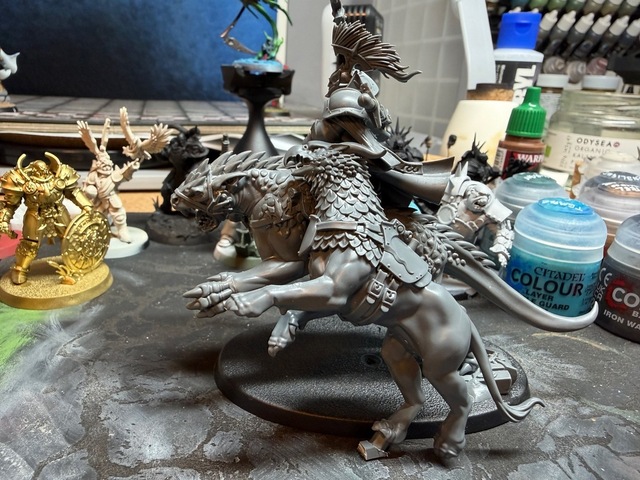 Photo of a gryph-charger model angled upright, leaning against a dracoline model which is the same height in standard pose