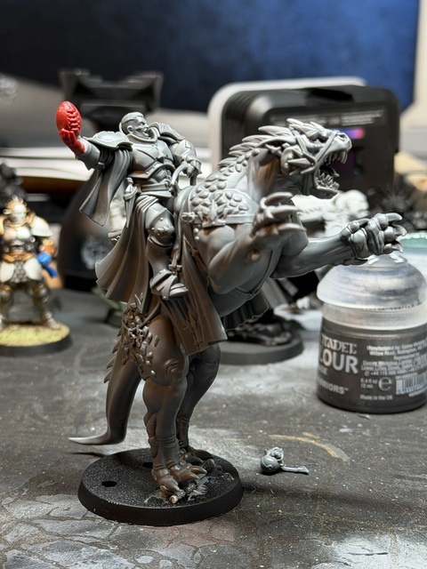 Photograph of a converted, unpainted dracoline miniature. It’s standing up on hind legs, with the rider holding a Blood Bowl ball instead of a staff.
