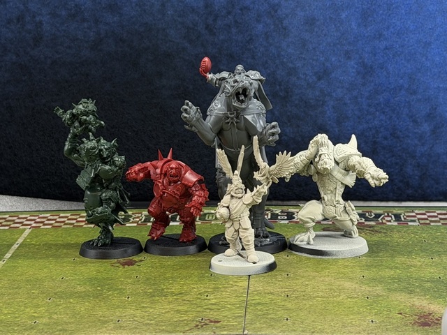 Photo of some Blood Bowl big guys lined up for size comparison. The trained troll, ogre and Skrorg Snowpelt are alongside the converted dracoline. Skrorg comes up to the dracoline's elbow, while the troll's raised arm just about reaches its shoulder. Griff Oberwald is in front of the dracoline, around half its height