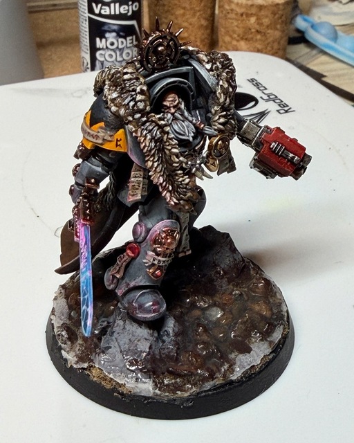 Photo of the terminator battle leader, based on the Leviathan terminator captain model. The various scrolls have had text added, with more legible runes added to the larger scrolls on his shin and shoulder pad. The power sword has a blue lightning-type effect along it, with the runes ‘lit’ in a fluorescent magenta that needs more work. There’s some quite subtle pink OSL on other elements to show the glow of the sword