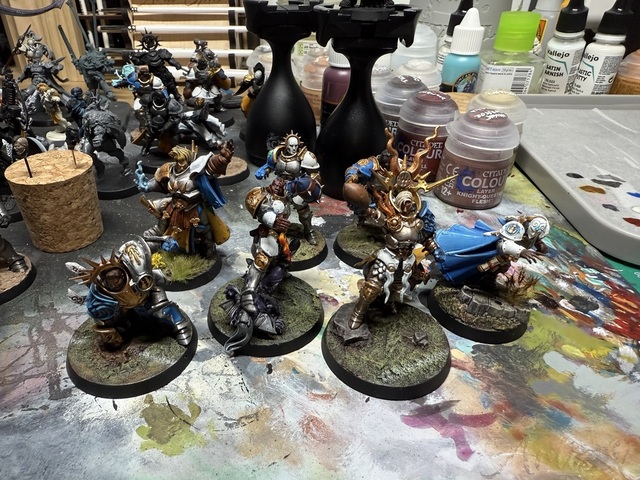 Photo of 7 painted Stormcast Eternals that have been converted to look like Blood Bowl players, standing on a paint-covered desk