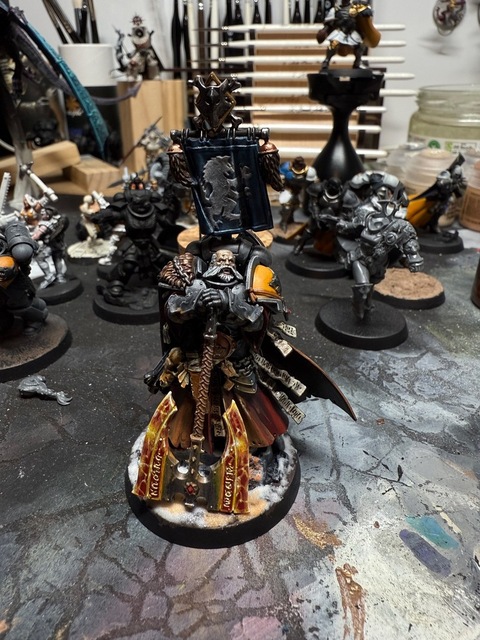 Photograph of a Lord-Terminos model that has been converted as a Space Wolves Space Marine. A grey and yellow gravis shoulder pad has been added to the left shoulder, while the axe is now two-headed and painted in a red-and-yellow lightning/crackle power effect. The head is a bearded Space Wolves head, while a backpack with banner has been added to his back
