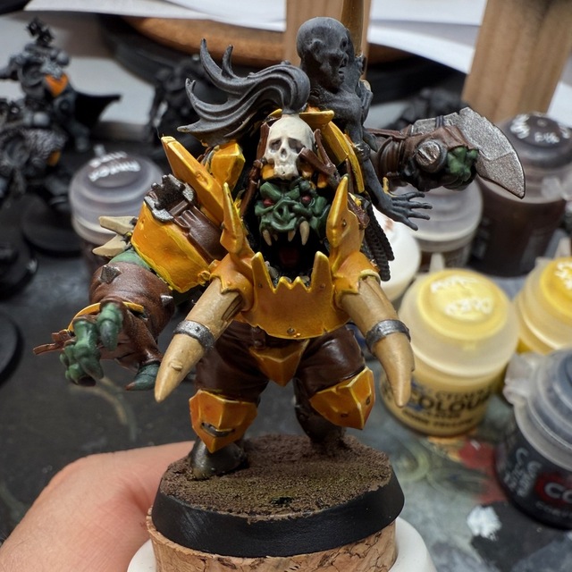 Photograph of a part-painted Varag Ghoul-Chewer miniature. The armour is a deep orangey yellow, with some edge highlights picked out. Much of the rest of the model just has flat base colours