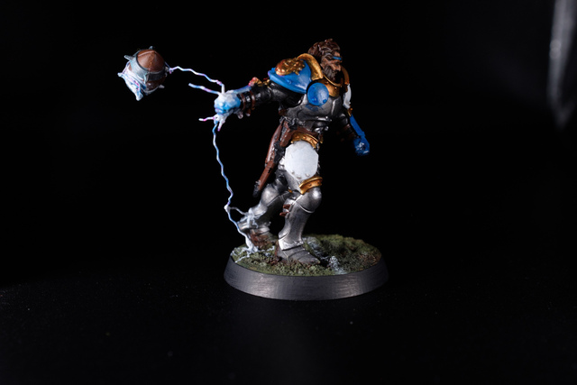 Photograph of the lineman conversion, with a ‘lightning lasso’ being swung round. The painted wire pulls out from the model’s hand to wrap around a ball trailing in the air behind, and also down from the hand to the floor, also branching off to the metal-armoured ankle.